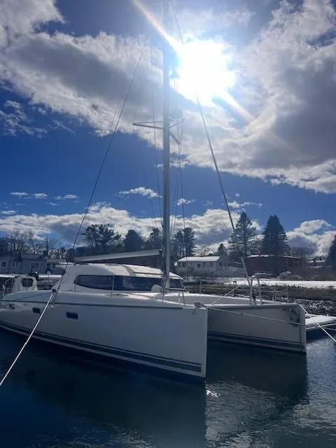 Slide: The Image of 2011 Nautitech 402 catamaran docked under a bright sun and cloudy sky. - 12