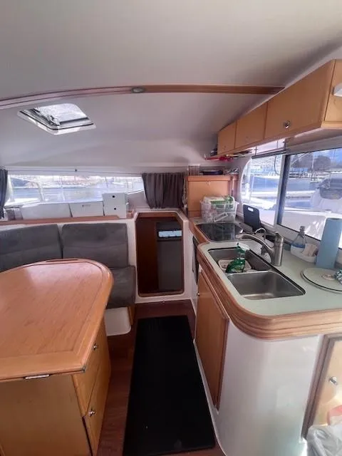 Slide: The Image of Interior of 2011 Nautitech 402 catamaran, featuring kitchen and dining area with wooden finishes. - 23