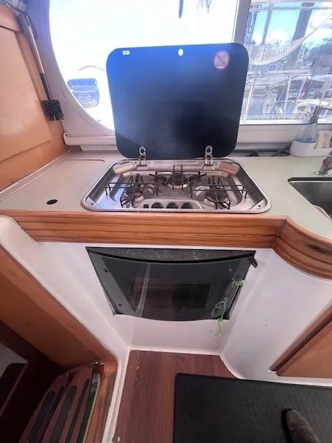 Slide: The Image of 2011 Nautitech 402 yacht kitchen with stove and oven, featuring a sleek design. - 24