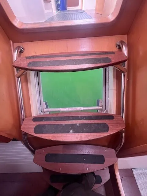 Slide: The Image of Wooden steps inside a 2011 Nautitech 402 catamaran, leading to a green-hued exterior. - 30