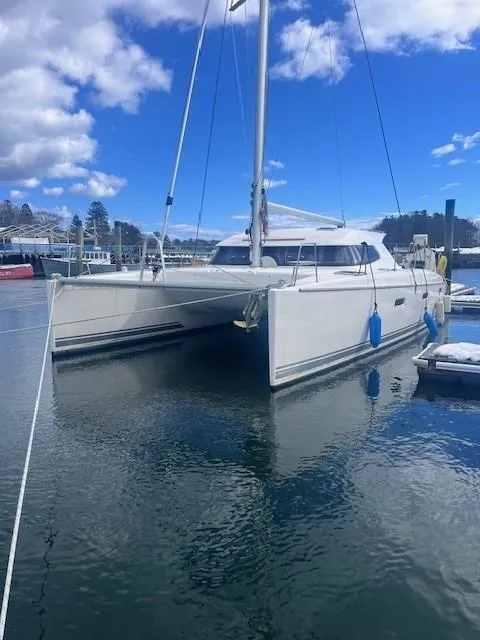 Slide: The Image of 2011 Nautitech 402 catamaran docked in a serene marina under a blue sky. - 43