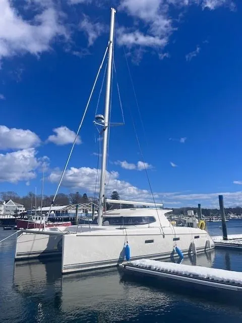 Slide: The Image of 2011 Nautitech 402 catamaran docked at a marina under a clear blue sky. - 9