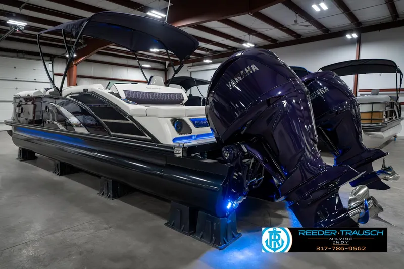 Slide: The Image of 2025 Bennington QX SB T2 boat with dual Yamaha engines in a showroom. - 10
