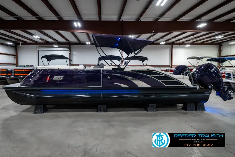 Slide: The Image of 2025 Bennington QX SB T2 pontoon boat in showroom, side view with canopy. - 11