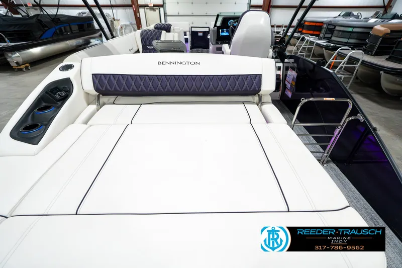 Slide: The Image of 2025 Bennington QX SB T2 boat interior with luxurious seating in a showroom. - 19
