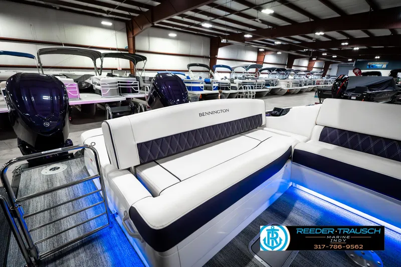 Slide: The Image of 2025 Bennington QX SB T2 pontoon boat interior with illuminated seating in a showroom. - 32