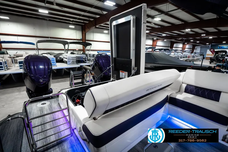Slide: The Image of 2025 Bennington QX SB T2 boat interior with seating and blue LED lighting in showroom. - 35