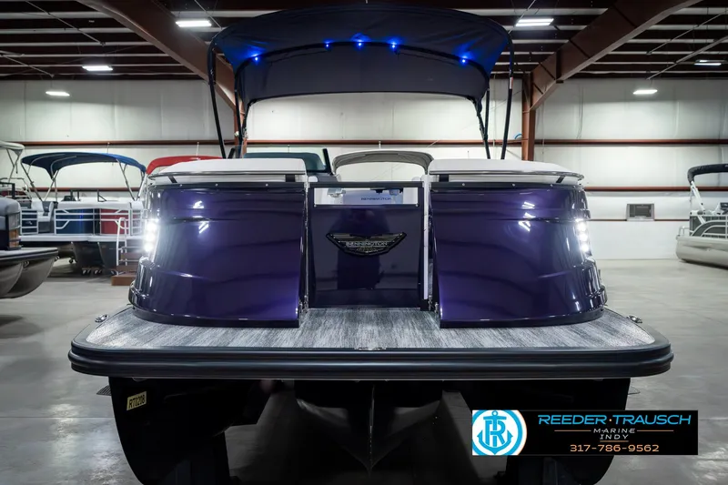 Slide: The Image of 2025 Bennington QX SB T2 pontoon boat in showroom with blue lighting. - 5