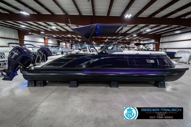 Slide: The Image of 2025 Bennington QX SB T2 pontoon boat in showroom, side view, with dual engines. - 7