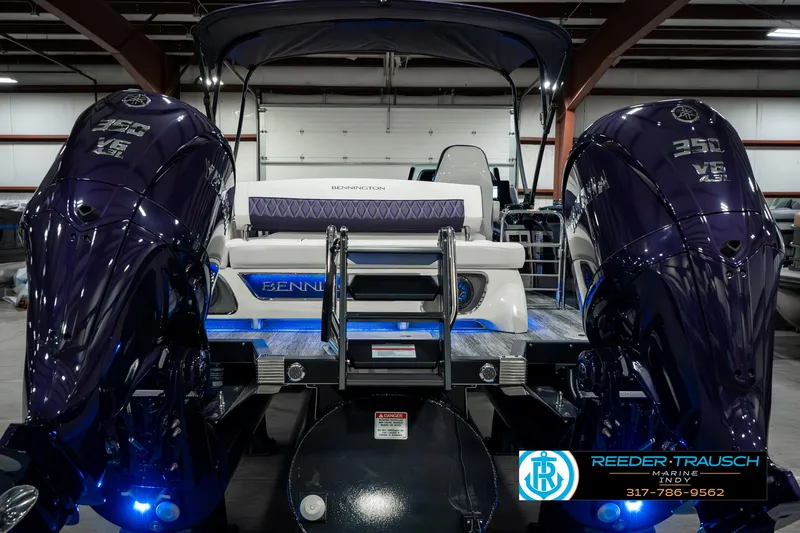 Slide: The Image of 2025 Bennington QX SB T2 boat with dual engines in a showroom. - 9