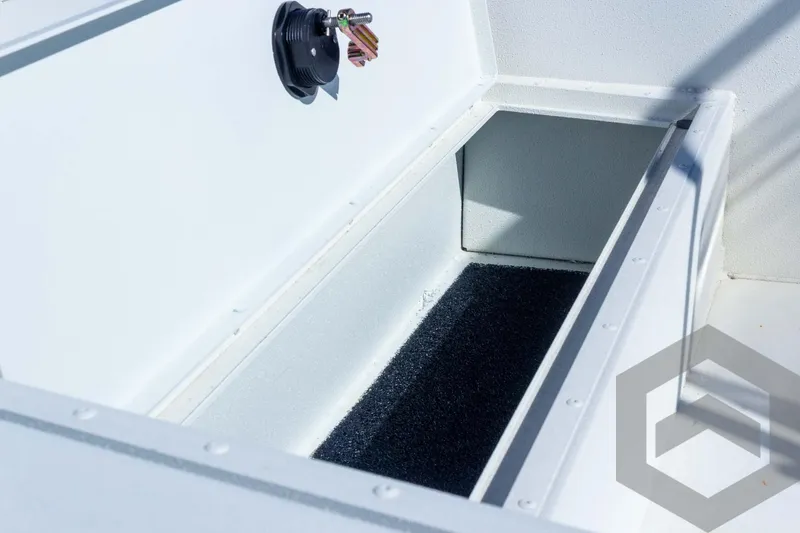 Slide: The Image of 2025 G3 Bay 21 GX boat storage compartment with open lid and latch. - 32