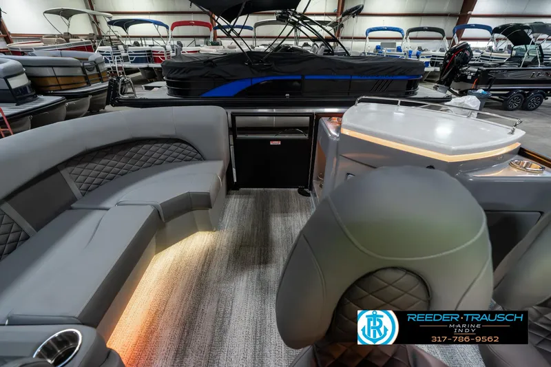 Slide: The Image of 2025 Bennington 23 LPD boat interior with luxurious seating and ambient lighting in showroom. - 18
