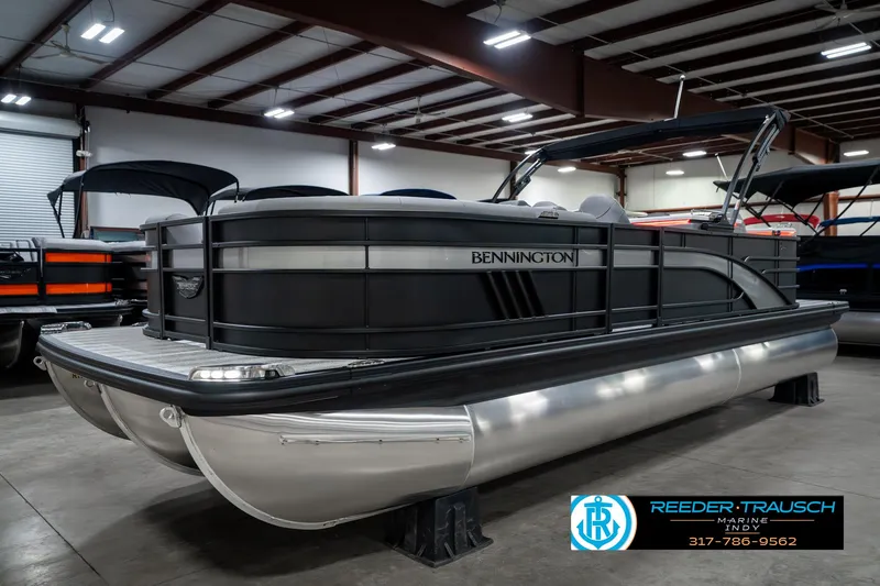 Slide: The Image of 2025 Bennington 23 LPD pontoon boat in showroom, featuring sleek design and modern amenities. - 2
