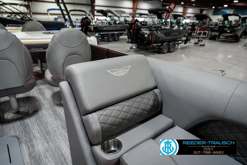 Slide: The Image of 2025 Bennington 23 LPD boat interior with gray seating and cup holder in showroom. - 24