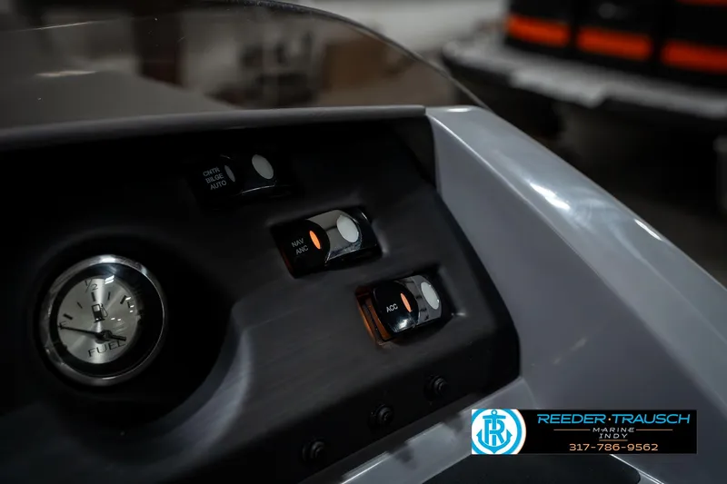 Slide: The Image of Dashboard controls of a 2025 Bennington 23 LPD boat with clock and switches. - 36
