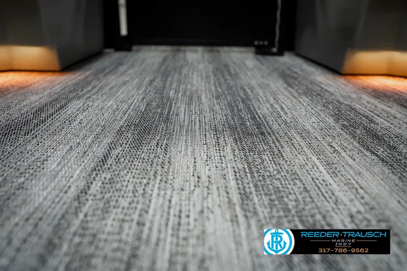 Slide: The Image of 2025 Bennington 23 LPD boat interior with textured flooring and ambient lighting. - 46