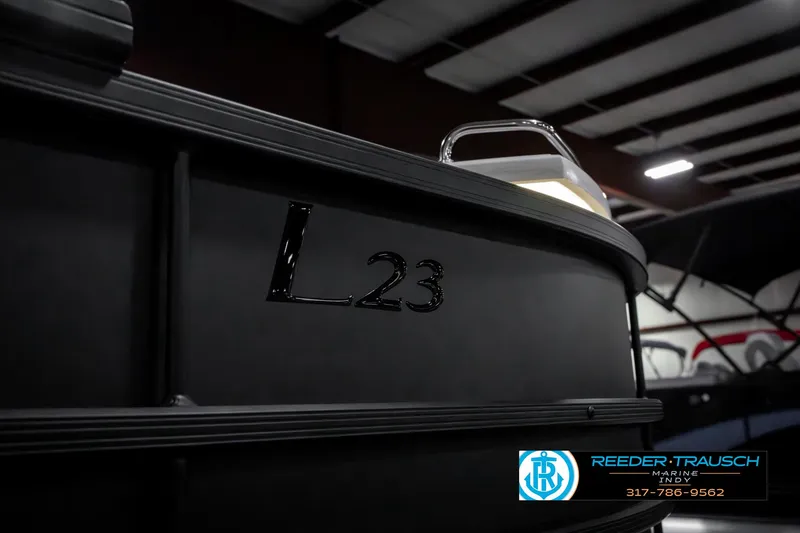 Slide: The Image of 2025 Bennington 23 LPD boat in showroom, featuring sleek black design. - 49