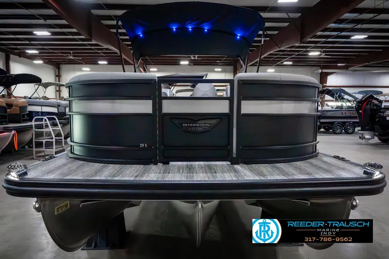 Slide: The Image of 2025 Bennington 23 LPD pontoon boat in showroom, rear view with blue LED lights. - 5