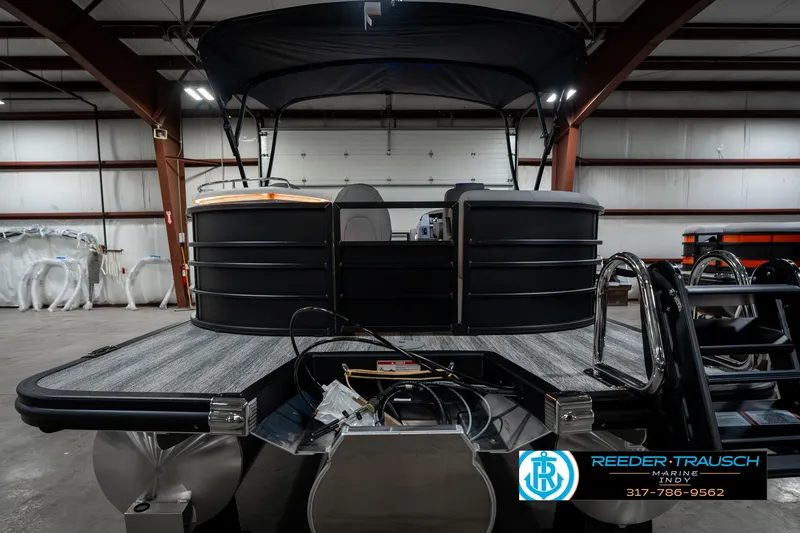 Slide: The Image of 2025 Bennington 23 LPD pontoon boat in a warehouse, featuring a sleek black design. - 9
