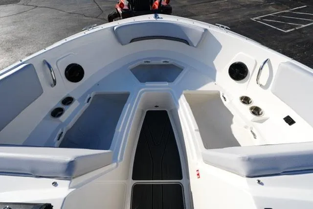 Slide: The Image of Bayliner V20 2025 boat interior with cushioned seating and cup holders. - 11