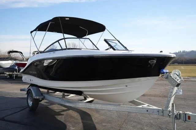 Slide: The Image of 2025 Bayliner V20 boat on trailer, black and white design, parked outdoors. - 4