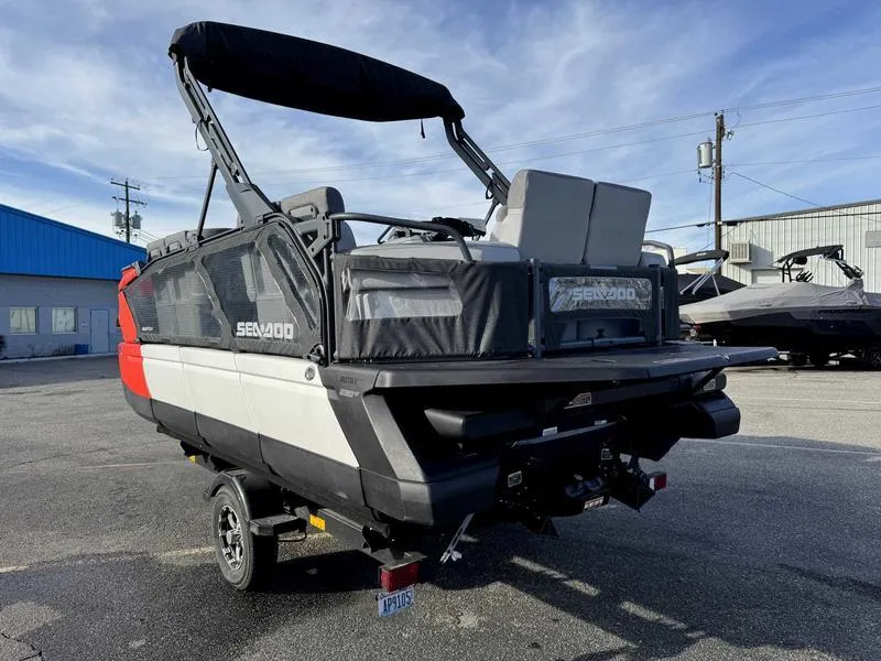 Slide: The Image of 2023 Sea-Doo Switch Cruise 18' pontoon boat in a parking lot, rear view. - 6