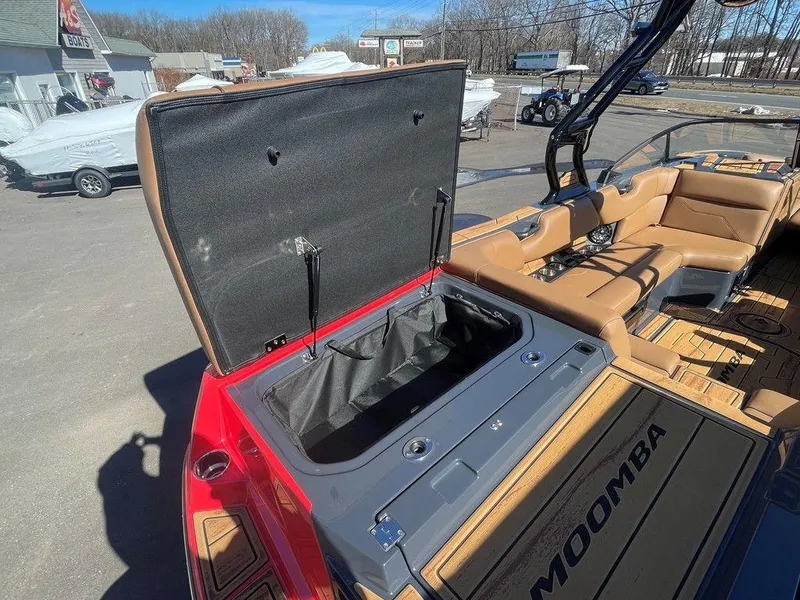 Slide: The Image of 2025 Moomba Max boat with open storage compartment and tan seating. - 16