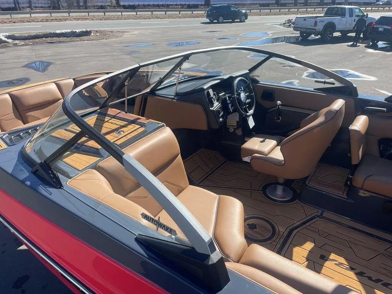 Slide: The Image of 2025 Moomba Max boat interior with tan seats and modern dashboard in a parking lot. - 19