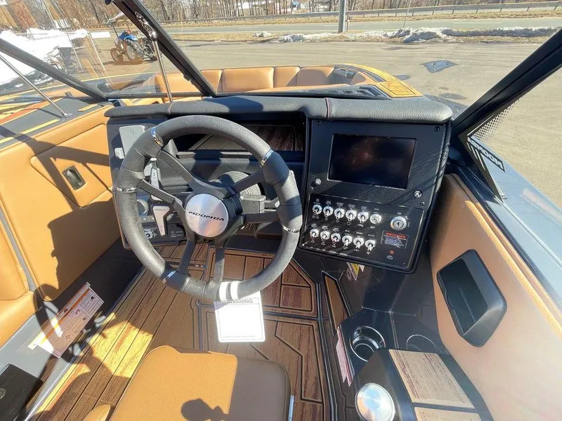 Slide: The Image of 2025 Moomba Max boat interior with steering wheel and control panel. - 21