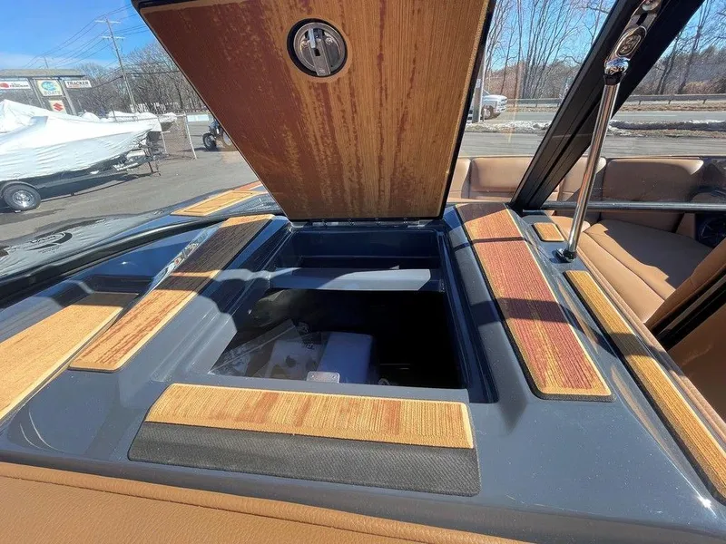 Slide: The Image of 2025 Moomba Max boat interior with open storage compartment and wood accents. - 26
