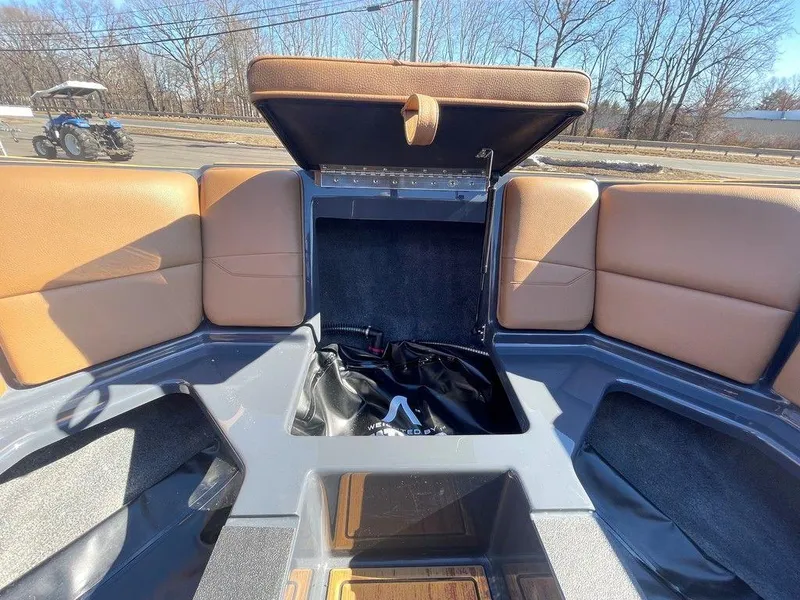 Slide: The Image of 2025 Moomba Max boat interior with open storage compartment and tan seating. - 29