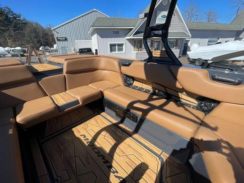 Slide: The Image of 2025 Moomba Max boat interior with tan seating and wood flooring. - 33