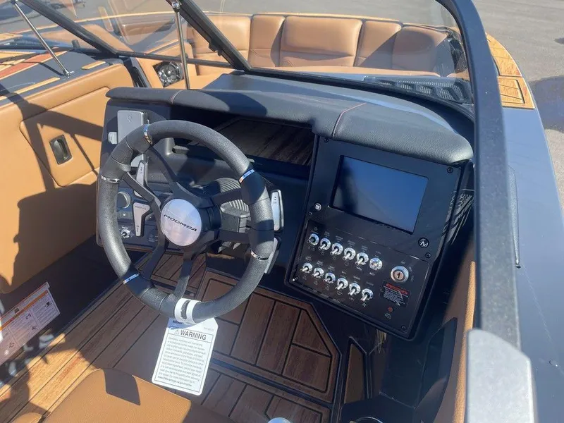 Slide: The Image of 2025 Moomba Max boat dashboard with steering wheel and control panel. - 36