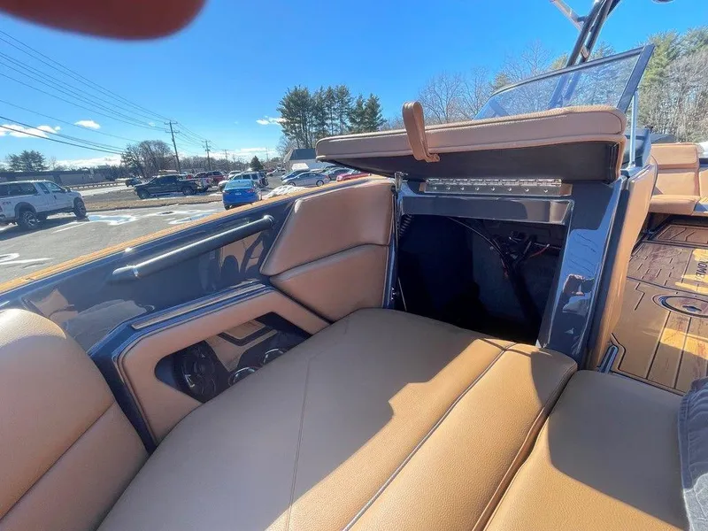 Slide: The Image of 2025 Moomba Max boat interior with tan seating and open storage compartment. - 39