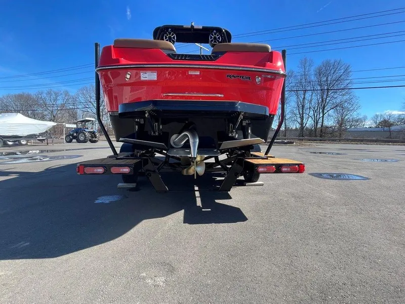 Slide: The Image of 2025 Moomba Max boat, rear view, red color, parked on pavement under clear blue sky. - 6