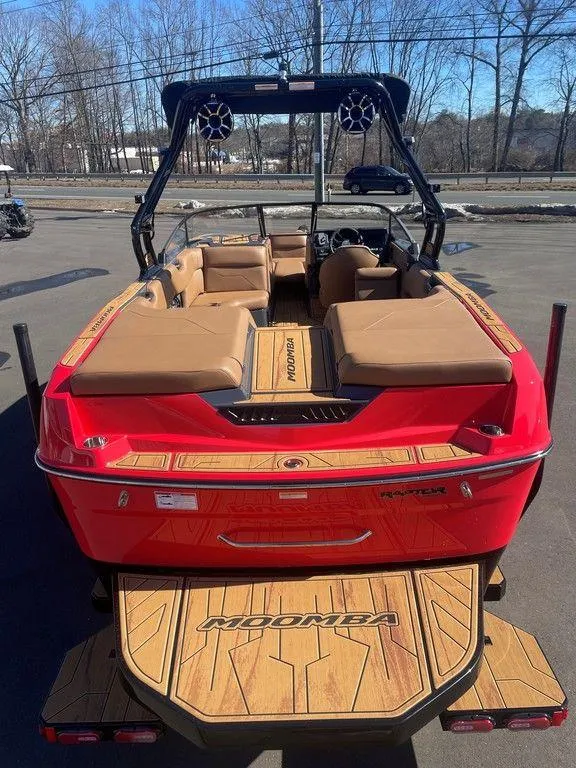Slide: The Image of 2025 Moomba Max boat with red exterior and tan interior, parked outdoors. - 9