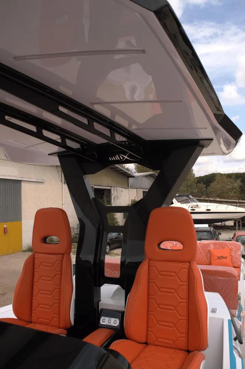 Slide: The Image of Orange seats on a DNA 46 boat, 2025 model, with sleek black frame and canopy. - 10
