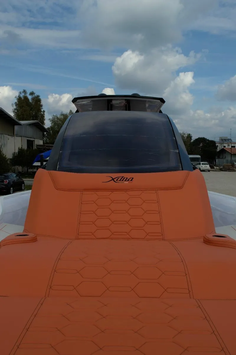 Slide: The Image of Futuristic DNA 46 model boat with orange seating, 2025 design, under a cloudy sky. - 17