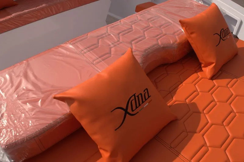 Slide: The Image of Orange DNA 46 boat seating with hexagonal pattern and branded cushions, 2025 model. - 18