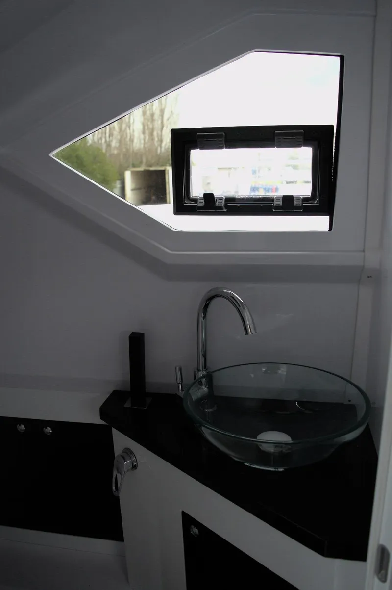 Slide: The Image of Modern bathroom interior in DNA 46, 2025 model, featuring glass sink and geometric window. - 21