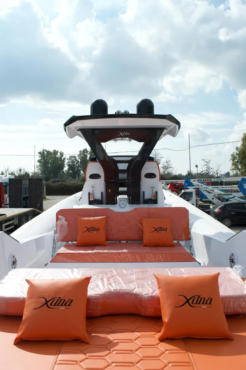 Slide: The Image of Luxury DNA 46 yacht, 2025 model, with orange seating and cushions under a cloudy sky. - 3