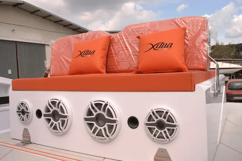Slide: The Image of Orange seating with branded cushions on a DNA 46 boat, featuring four speakers. - 4