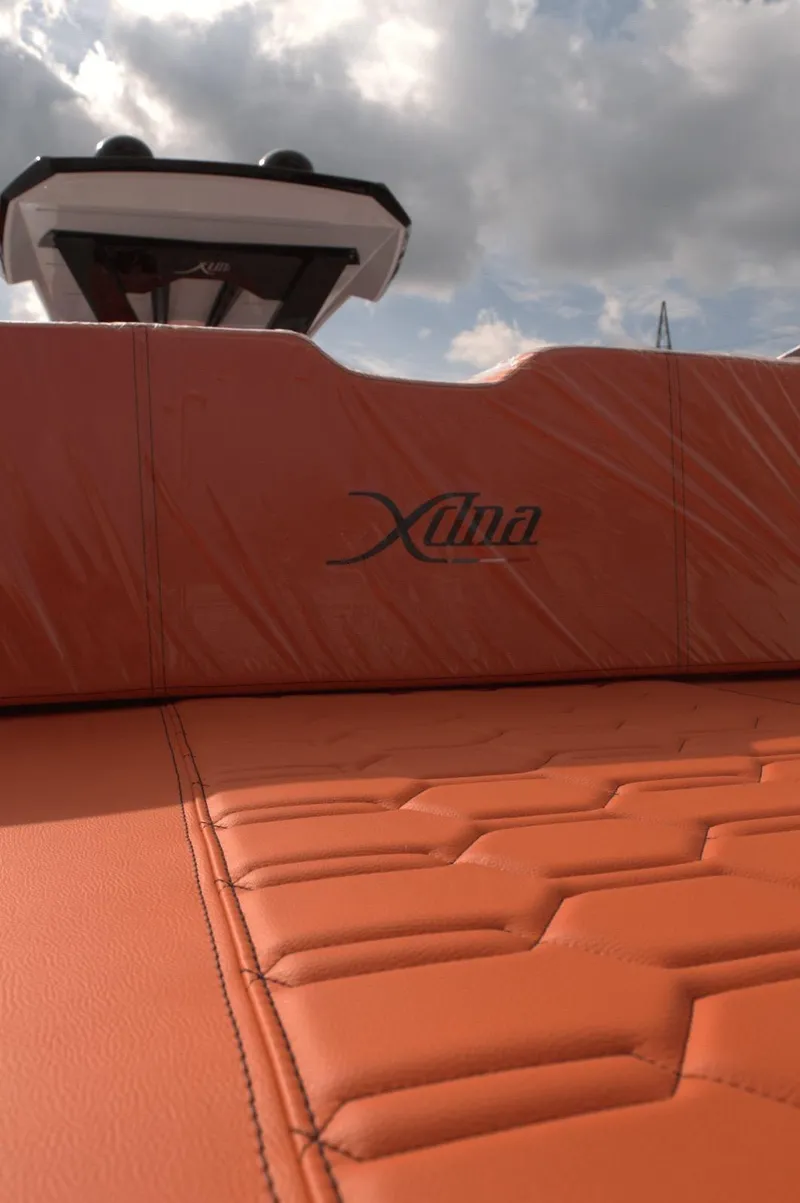 Slide: The Image of Orange leather seating on a 2025 DNA 46 boat under a cloudy sky. - 9