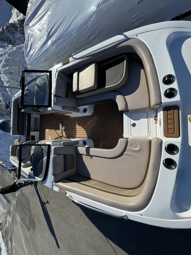 Slide: The Image of 2018 Hurricane SunDeck 217 OB boat interior with beige seating and wood flooring. - 10
