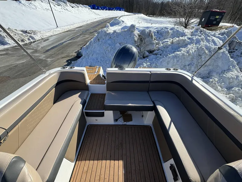 Slide: The Image of 2018 Hurricane SunDeck 217 OB boat interior with cushioned seating, snowy background. - 12