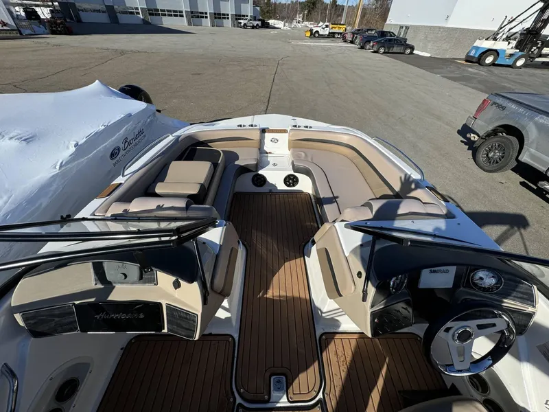 Slide: The Image of 2018 Hurricane SunDeck 217 OB boat interior with seating and steering wheel, parked outdoors. - 9