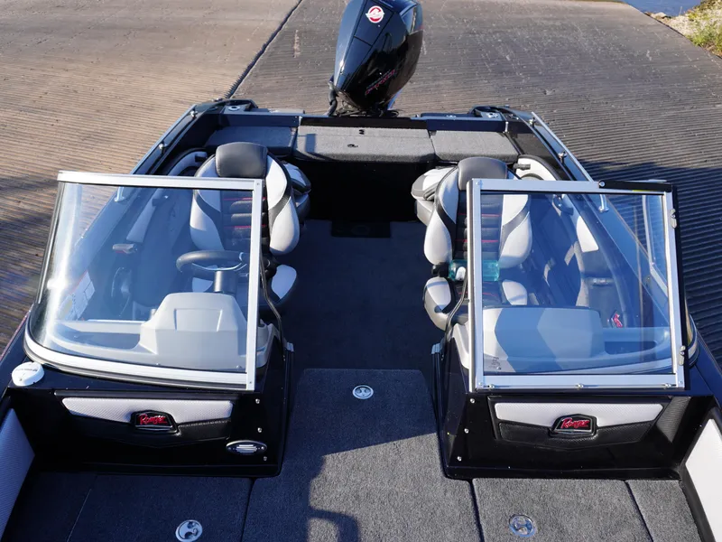Slide: The Image of 2025 Ranger 1880MS boat interior with seating and windshield, docked on a ramp. - 12