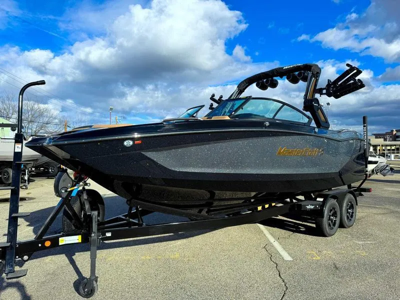 Slide: The Image of 2025 MasterCraft X24 boat on trailer under cloudy sky. - 3