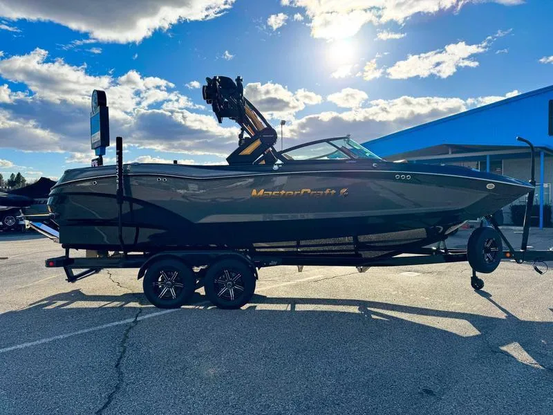 Slide: The Image of 2025 MasterCraft X24 boat on trailer under a bright blue sky. - 5