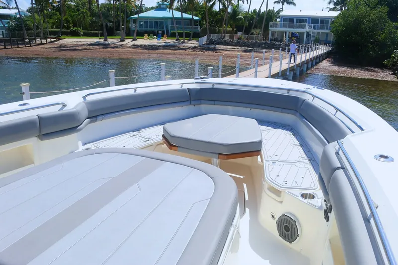 Slide: The Image of Boston Whaler 380 Outrage 2022 boat with spacious seating and scenic dock view. - 10
